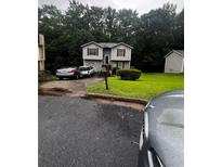 Charming two-story home featuring gray siding, red shutters, and a well-maintained front lawn at 5568 Bradley Cir, Lithonia, GA 30038