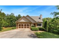Charming home with a stone-accented facade, manicured lawn, and attached two-car garage at 179 Oakville Dr, Dallas, GA 30157