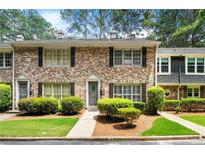 Charming brick townhouse with manicured landscaping and classic black shutters on the windows at 2435 Northlake Ct, Atlanta, GA 30345