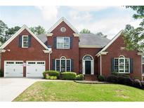 Beautiful red brick home with black shutters, a two-car garage and a well-maintained lawn at 4046 Creekview Ridge Dr, Buford, GA 30518