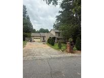 Charming split-level home with attached garage, mature trees, and a quaint front yard at 616 Burnt Creek Nw Way, Lilburn, GA 30047