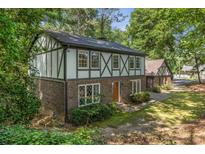 Charming two-story Tudor home featuring a brick facade and decorative wood trim surrounded by mature trees at 965 Heards Ferry Rd, Sandy Springs, GA 30328