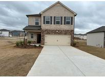 Two-story home featuring a two-car garage and a mix of brick and siding on the facade at 1001 Limburg Dr, Hampton, GA 30228