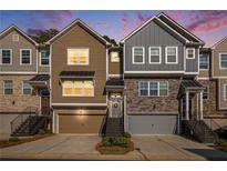Charming townhomes with two-car garages and landscaped front yards at twilight at 2517 Hedgeway Cir, Kennesaw, GA 30144