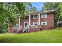 Traditional brick home featuring white columns and shutters, surrounded by lush greenery at 5247 Yeager Rd, Douglasville, GA 30135