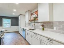 Bright kitchen features white cabinets, modern countertops, stainless steel appliances, and stylish backsplash at 364 Stafford Sw St, Marietta, GA 30064