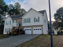 Traditional two-story home boasts a two-car garage, complemented by a mix of siding and brick exterior at 2775 Emerald Springs Dr, Lawrenceville, GA 30045