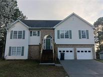 Charming two-story home with brick accents, a two-car garage, and a welcoming front porch with stairs at 2775 Emerald Springs Dr, Lawrenceville, GA 30045