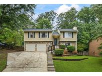 Charming two-story home featuring stone accents, a two-car garage, and a well-manicured front yard at 735 Waterbrook Ter, Roswell, GA 30076
