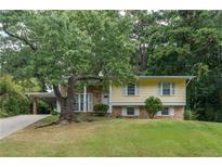 Charming yellow home with brick accents, well-manicured lawn, and mature trees offering shade and curb appeal at 2510 Brentwood Ct, Decatur, GA 30032