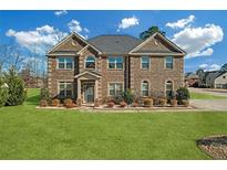 Charming two-story brick home with a manicured lawn and inviting front entrance at 4580 Cloister Cir, Hampton, GA 30228