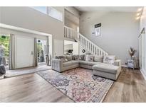 Bright living room features high ceilings, statement staircase, and modern sectional sofa at 4117 Signal Sw Rdg, Lilburn, GA 30047