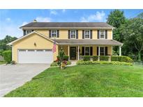 Charming yellow two-story home with a welcoming front porch and well-manicured lawn at 1083 Wash Lee Sw Dr, Lilburn, GA 30047