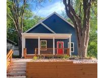 Charming home features a covered porch, red front door, and well-maintained landscaping at 1321 Bridges Sw Ave, Atlanta, GA 30310
