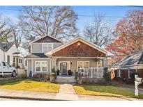 Charming two-story home with craftsman details, a welcoming front porch, and mature trees at 1450 Elizabeth Ln, Atlanta, GA 30344