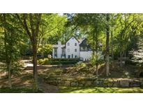 Charming exterior view of the home with a landscaped front yard and stone retaining wall at 6305 River Chase Cir, Atlanta, GA 30328