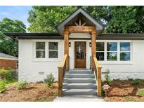 Charming exterior showcasing a white brick facade, gray trim, and welcoming wooden front porch at 2244 Alpha Dr, Decatur, GA 30032