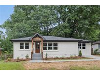 Charming one-story home with white painted brick, stone accents, and a covered front porch at 2244 Alpha Dr, Decatur, GA 30032