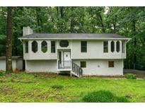 Charming two-story home with unique windows and stone accents, nestled amongst lush trees at 3066 Malvern Dr, Snellville, GA 30039