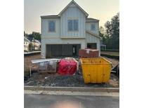 New construction home featuring a light-colored exterior, an attached garage, and construction materials at 3006 Sea Aster Way, Buford, GA 30519