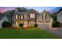 Charming two-story home with a well-manicured lawn, inviting front porch, and two-car garage at 4009 Riverstone Dr, Suwanee, GA 30024