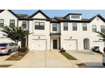 Charming townhome with white brick, black trim, garage, and modern design at 32 S Auburn Landing Pl, Auburn, GA 30011