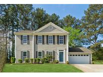 Charming two-story home with a well-manicured lawn, attached garage, and complemented by mature trees at 4147 Pinehurst Valley Dr, Decatur, GA 30034