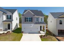 Charming two-story home featuring a one car garage and manicured front lawn at 12085 Conrad Circle, Hampton, GA 30228