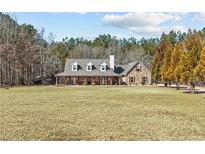 Charming brick home featuring a long front porch and a well-maintained yard at 212 Lakeview Dr, Newborn, GA 30056