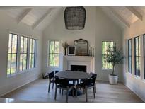 Bright dining room with a fireplace, large windows, a vaulted ceiling, and a modern light fixture at 1303 Cobblemill Nw Way, Kennesaw, GA 30152