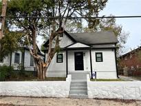 Charming renovated home with a black front door, gray stairs, and a manicured stone wall at 701 Cameron M Alexander Nw Blvd, Atlanta, GA 30318