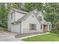 Traditional two-story home with a garage, siding, shutters, and a mature tree-filled landscaped lot at 3404 Bodiford Path Path, Powder Springs, GA 30127