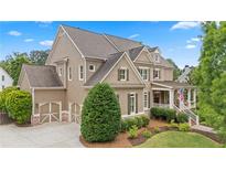 Charming home with neutral siding, covered porch, manicured lawn, and attached two-car garage at 4530 Westgate Dr, Cumming, GA 30040