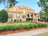 Inviting two-story home featuring a covered porch, landscaped yard, and neutral-toned exterior at 4530 Westgate Dr, Cumming, GA 30040