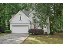 Charming two-story home with a well-maintained lawn, two car garage and a welcoming red front door at 220 Chinkapin Sw Cir, South Fulton, GA 30311