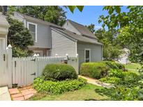 Charming townhome with white picket fence and lush landscaping adding curb appeal at 2694 Greentree Se Dr, Marietta, GA 30067