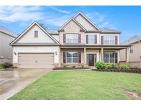 Charming two-story home featuring a manicured lawn, covered porch, brick accents, and an attached two-car garage at 726 Independence Ln, Acworth, GA 30102