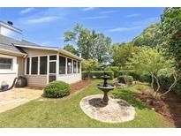 Charming backyard oasis with a water fountain, screened-in porch, and lush greenery at 2265 Colony Dr, Canton, GA 30114