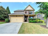 Charming two-story home with a brick and siding exterior, attached garage, and well-manicured lawn at 1205 Apple Blossom Dr, Cumming, GA 30041