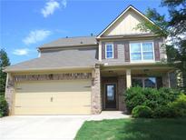 Two-story home with a brick and beige facade and a two-car garage, exuding suburban charm at 1205 Apple Blossom Dr, Cumming, GA 30041