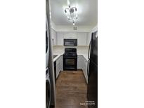 Galley kitchen featuring gray cabinets, stainless steel appliances, and hardwood floors at 2479 Peachtree Ne Rd # 902, Atlanta, GA 30305