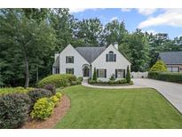 Charming white home with manicured lawn, lush landscaping, and black shutters, creating a welcoming curb appeal at 3648 Sope Creek Farm Se, Marietta, GA 30067