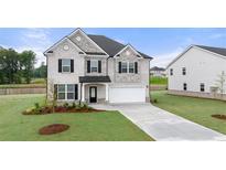 Beautiful two-story home boasts a brick facade, well-manicured lawn, and a spacious two-car garage at 291 Sandy Oak Dr, Loganville, GA 30052