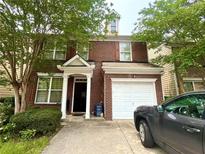 Charming two-story brick home with a covered entryway and attached single car garage at 1560 Park Grove Dr, Lawrenceville, GA 30046