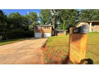 Charming brick home featuring a two-car garage, well-maintained lawn, and mailbox with visible street number at 2390 Tiffany Pl, Decatur, GA 30035