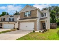 Charming two-story home boasts a brick and siding exterior, complemented by a two-car garage and a well-maintained lawn at 10814 Wheeler Trce, Hampton, GA 30228