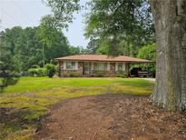 Charming brick home with a well-maintained lawn and covered parking at 2323 Cedar Terrace Rd, Lithia Springs, GA 30122
