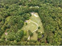 Expansive aerial view showcases the property's lush greenery and winding driveway at 891 Wooten Ct, Canton, GA 30114