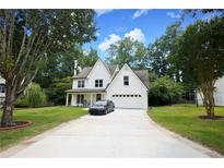 Charming two-story white home with well-maintained lawn, driveway and front yard at 455 Saddle Bow Dr, Lawrenceville, GA 30046