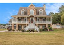 Charming two-story home with a welcoming front porch and beautiful stone and siding details at 92 River Walk Pkwy, Euharlee, GA 30145